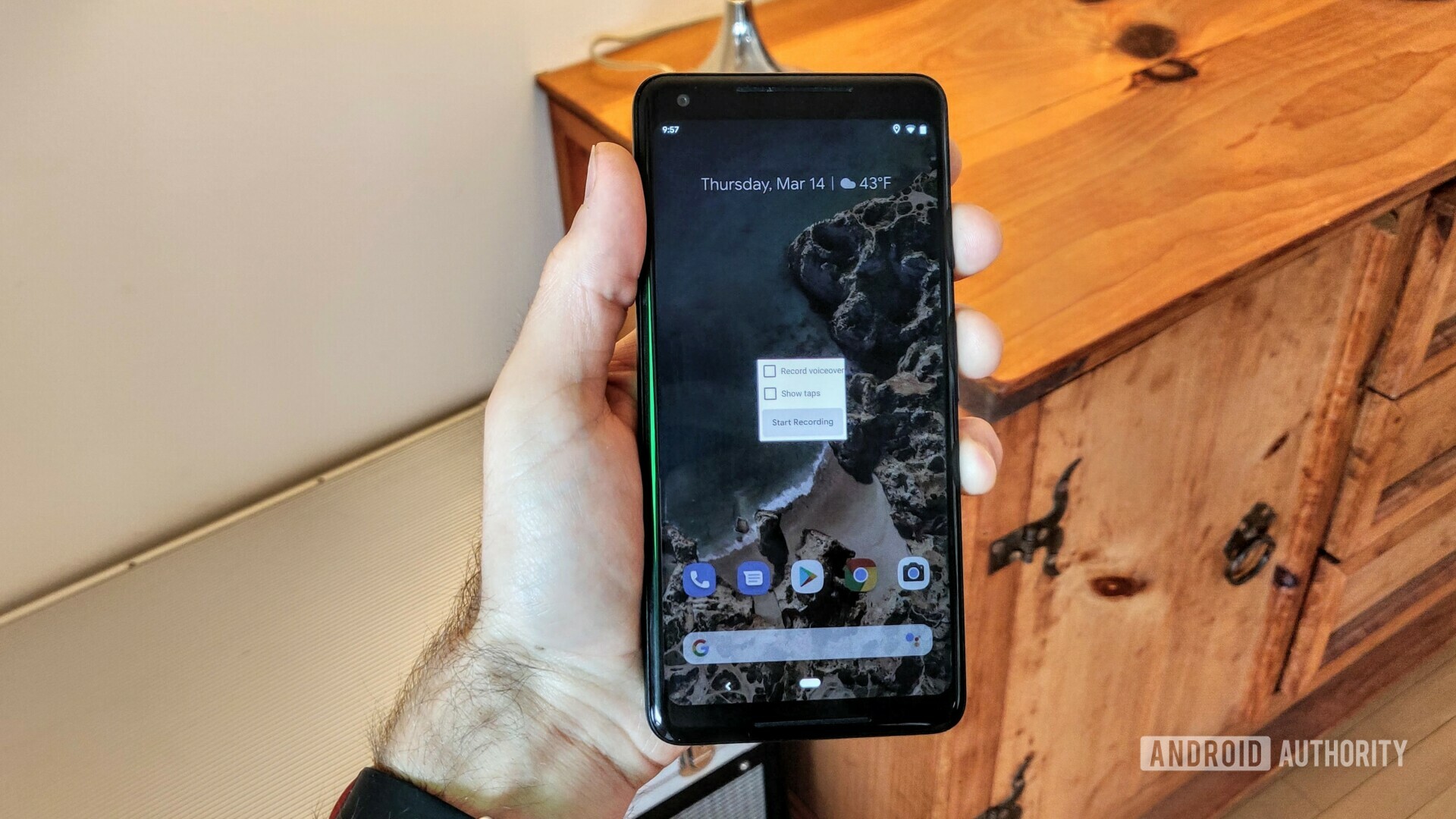 拿着一个谷歌像素2 xl的手的照片与显示的新的Android Q屏幕记录器。爱游戏刷手机版下载