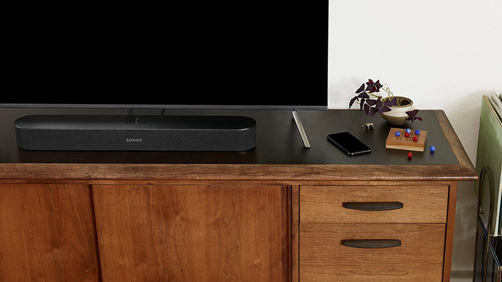 电视架上的黑色Sonos Beam Soundbar的图片。