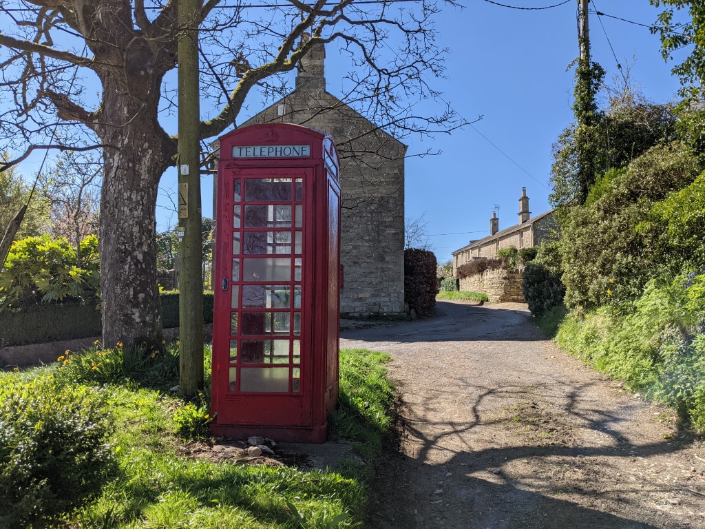 谷歌像素5相机颜色射击了在绿草的一台红色电话亭