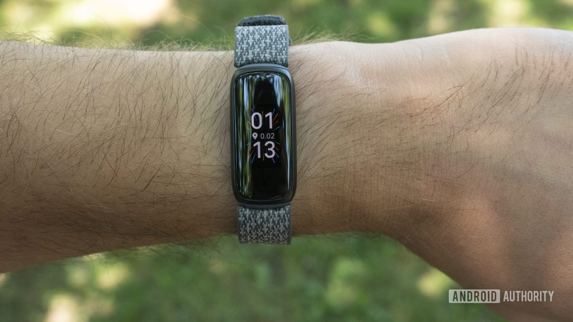 用户将Fitbit Luxe与带有编织的表带建模。
