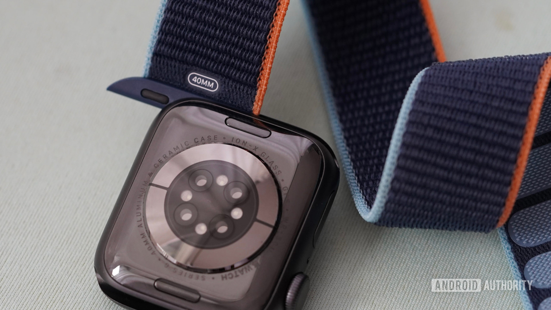 Apple Watch系列6放在浅蓝色的表面上，其尼龙带部分移除。